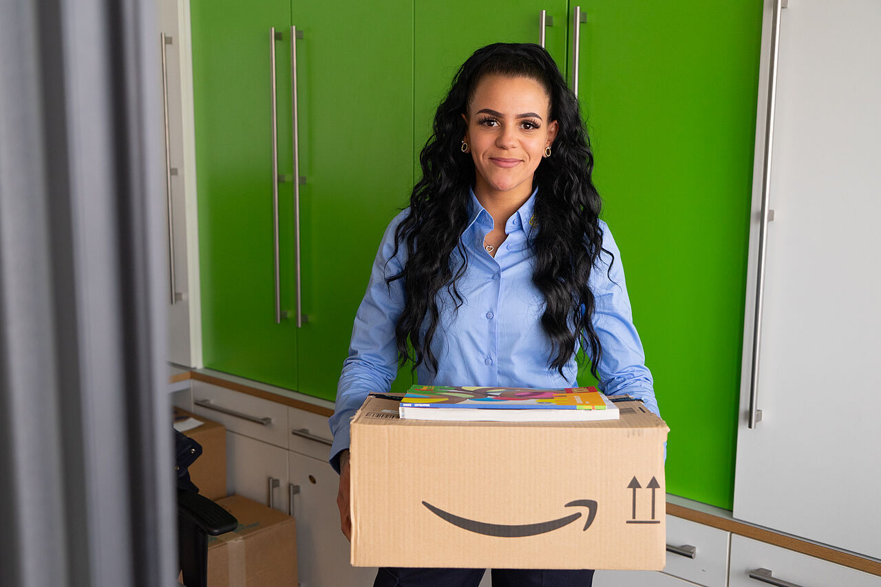Paketannahme Concierge-Service Concierge-Mitarbeiterin mit einem Paket in der Hand im Servicebereich eines Wohnhauses